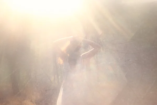 Сюрреалистичное фото молодой женщины, стоящей в лесу. изображение текстурировано и тонизировано — стоковое фото