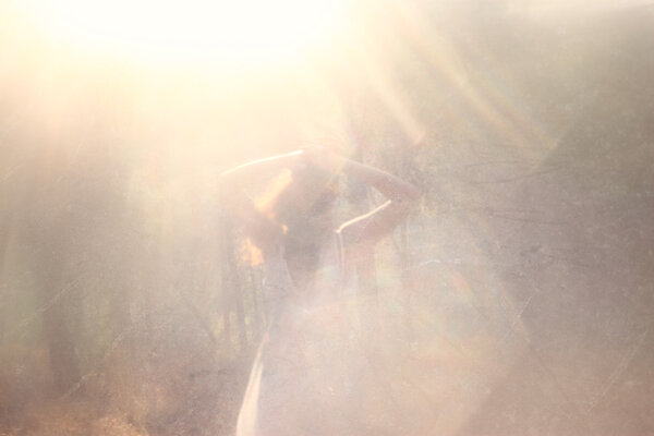 Surreal photo of young woman standing in forest. image is textured and toned. dreamy concept.