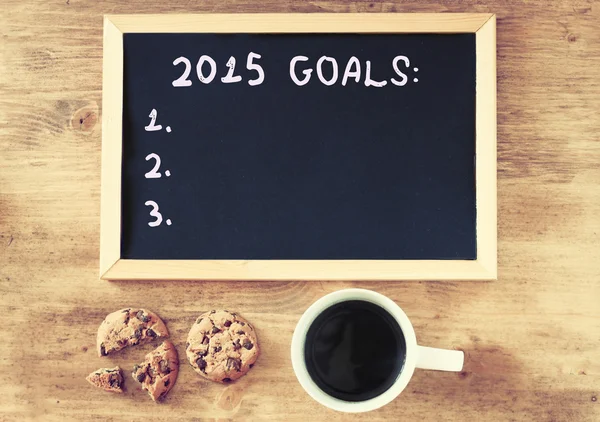 Вид зверху на дошку з фразою 2015 року цілі над дерев'яною дошкою з кавою та печивом — стокове фото