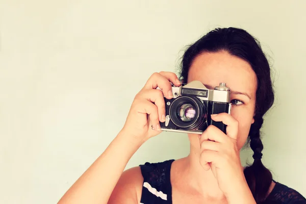 Mujer joven sosteniendo una vieja cámara. efecto vintage — Foto de Stock