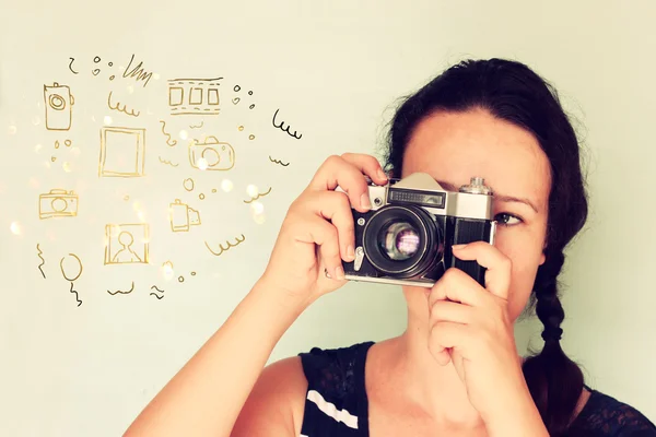 Mujer joven sosteniendo la vieja cámara y varios bocetos como su imaginación —  Fotos de Stock