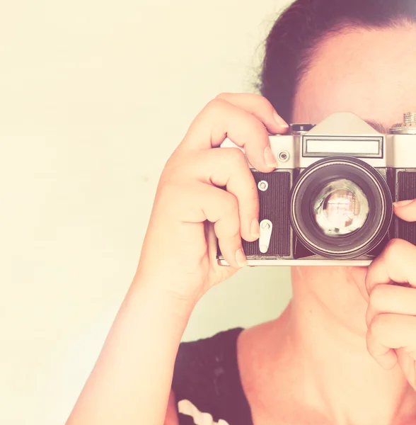 Jeune femme tenant une vieille caméra. effet vintage — Photo