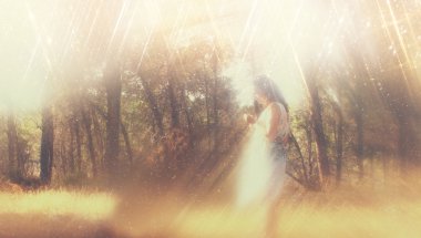 gerçeküstü arka plan bulanık bir genç kadın ormanda duruyor. soyut ve rüya gibi bir kavram. Görüntüyü dokulu ve retro tonlu