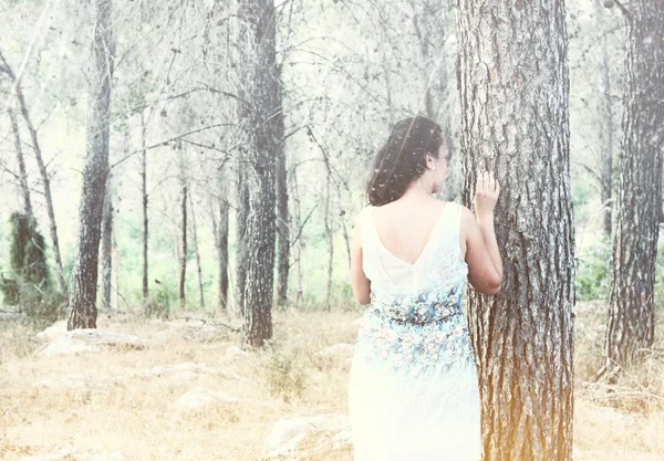 Сюрреалістичний розмитий фон молодої жінки стоїть у лісі. абстрактне і мрійливе поняття. зображення текстуроване і ретро тоноване — стокове фото