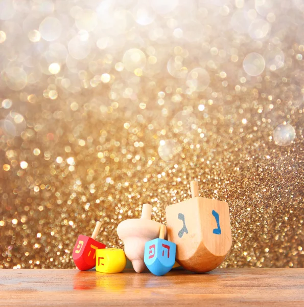 Dreidels de madera para Hanukkah y brillo dorado luces de fondo —  Fotos de Stock