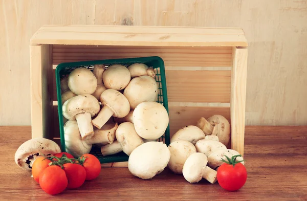 Fresh mufresh mushroom champignon in green rustic basket on wooden table — Stock Photo, Image