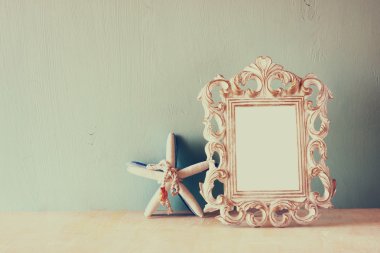 Vintage antik klasik çerçeve ve denizyıldızı ahşap masa üzerinde düşük anahtar görüntü. Filtre uygulanmış görüntü