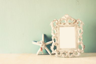 Vintage antik klasik çerçeve ve denizyıldızı ahşap masa üzerinde düşük anahtar görüntü. Filtre uygulanmış görüntü