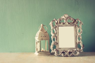 Vintage antik klasik çerçeve ve ahşap masa üzerinde beyaz fener düşük anahtar görüntü. Filtre uygulanmış görüntü