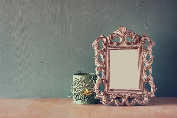 Low key image of vintage antique classical frame and white lantern on wooden table. filtered image — Stock Photo, Image