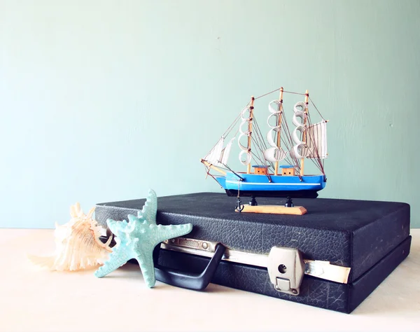 旧的老式提箱，他们与玩具船 ' 海星和木板上的贝壳。旅行和航行的概念。复古的滤波的图像 — 图库照片