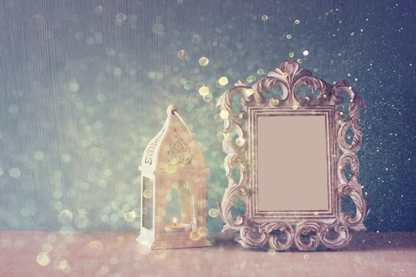 Lage sleutel imago van vintage antieke klassieke frame op houten tafel en glitter licht achtergrond. gefilterde afbeelding — Stockfoto