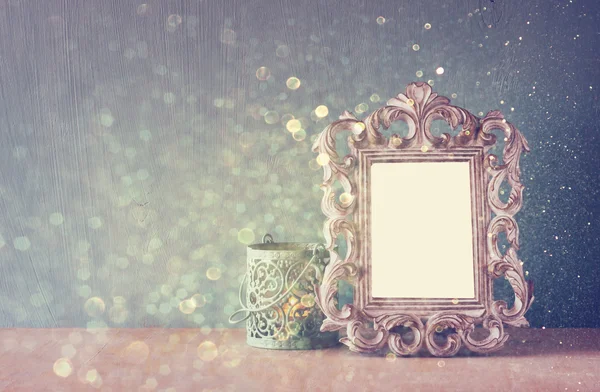 Lage sleutel imago van vintage antieke klassieke frame op houten tafel en glitter licht achtergrond. gefilterde afbeelding — Stockfoto