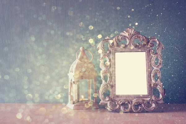 Low key image of vintage antique classical frame on wooden table and glitter lights background. filtered image — Stock Photo, Image