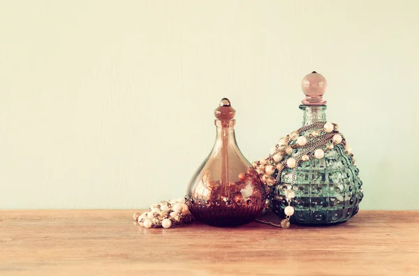 Vintage antigue perfume bottles, on wooden table. retro filtered image — Stock Photo, Image