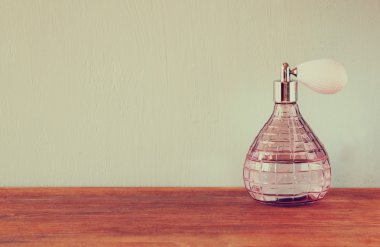 Vintage antik parfüm şişesi, ahşap masa üzerinde. Retro filtre uygulanmış görüntü