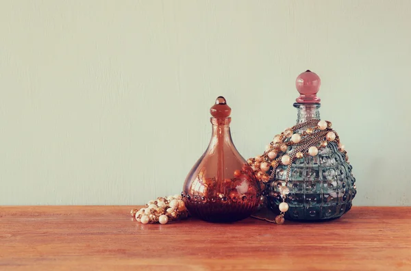 Bouteilles de parfum anciennes vintage, sur table en bois. image filtrée rétro — Photo