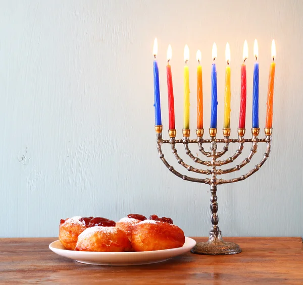 Jüdischer Feiertag Chanukka mit Menora, Donuts und hölzernen Dreideln (Kreisel)). — Stockfoto