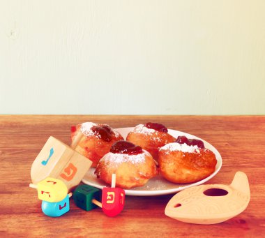 Ev yapımı çörek ve ahşap sevinçler (iplik üst) için hanukkah Yahudi tatil ahşap masa üzerinde. Retro filtre uygulanmış görüntü