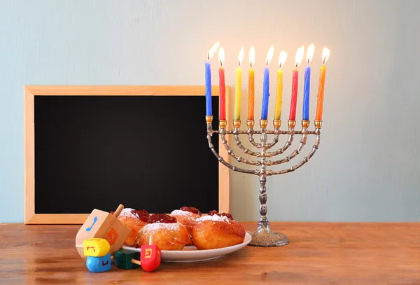 Yahudi tatil Hanukkah menorah, ahşap masa üzerinde çörek ile — Stok fotoğraf