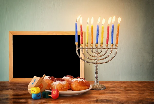 Εβραϊκή διακοπές Hanukkah με menorah, ντόνατς, πέρα από το ξύλινο τραπέζι. ρετρό φιλτραρισμένο εικόνα — Φωτογραφία Αρχείου