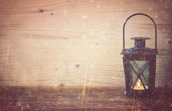 Vintage lantaarn op houten tafel en glitter licht achtergrond. gefilterde afbeelding — Stockfoto