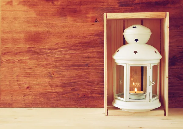 Vintage Lantern with burning Candle on wooden table. filtered image — Stock Photo, Image