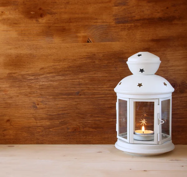 Linterna Vintage con vela encendida sobre mesa de madera. imagen filtrada — Foto de Stock