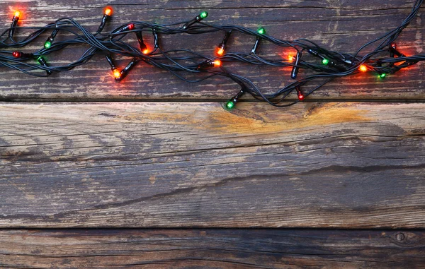 Colorate luci di Natale su sfondo rustico in legno. immagine filtrata — Foto Stock