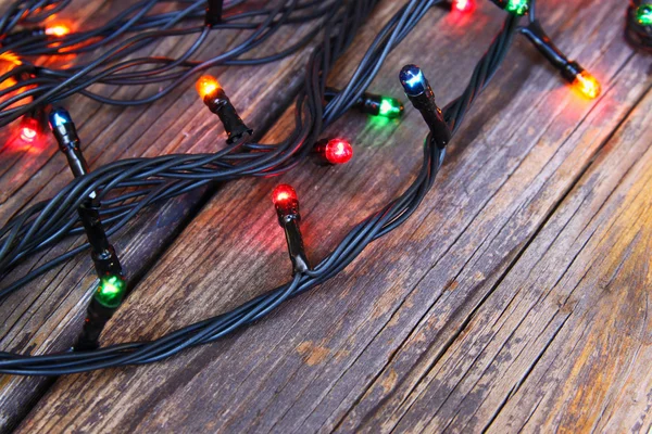 Färgglada Christmas lights på trä rustika bakgrund. filtrerade bilden — Stockfoto