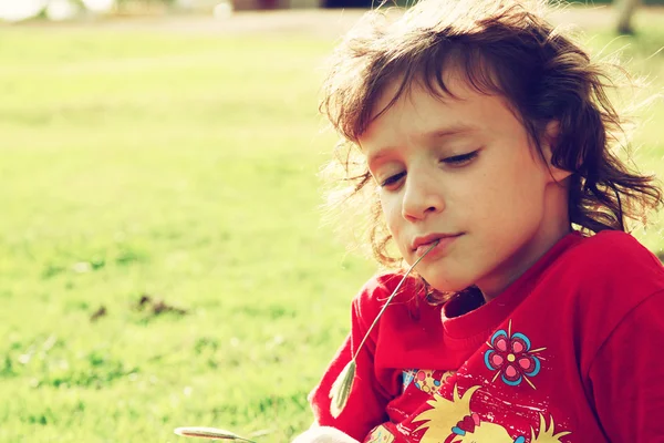 Menina encantadora brincando na grama no parque. imagem filtrada — Fotografia de Stock