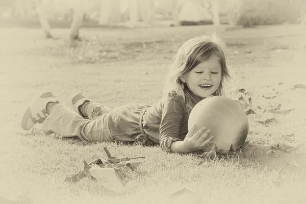 Vintage foto av lilla vackra flicka som leker i parken. retro gamla stil filtrerade bilden — Stockfoto