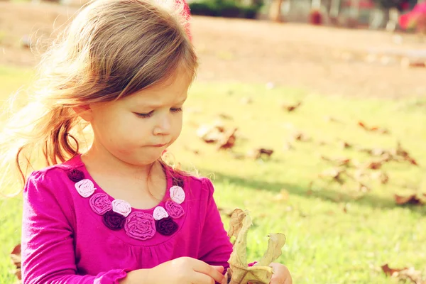 Little lovely girl playing on the grass in the park. filtered image — Stock Photo, Image