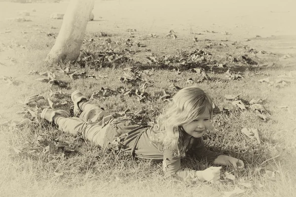 Foto vintage de una niña hermosa jugando en el parque. imagen filtrada estilo antiguo retro —  Fotos de Stock