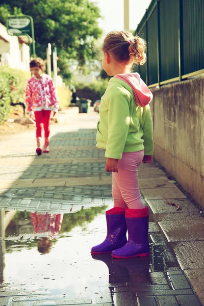 Słodkie dziewczynki gry i zabawy na ulicy, w jesienny dzień. retro filtrowanego obrazu — Zdjęcie stockowe