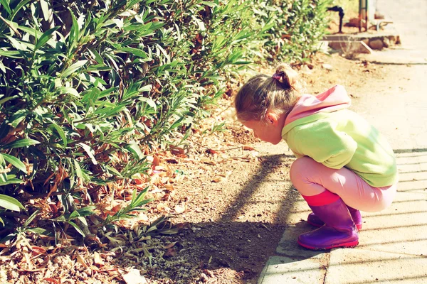 Linda niña jugando y divirtiéndose en la calle, en un día de otoño. imagen filtrada retro — Foto de Stock