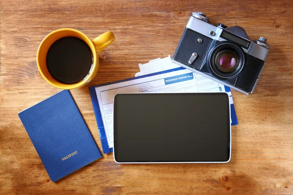 Top view of tablet with empty screen, passport and boarding pass over wooden table. travel concept — Stock Photo, Image