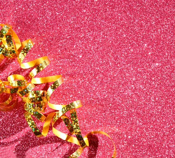 Top view image of curly gold ribbon over textured glitter background — Stock Photo, Image