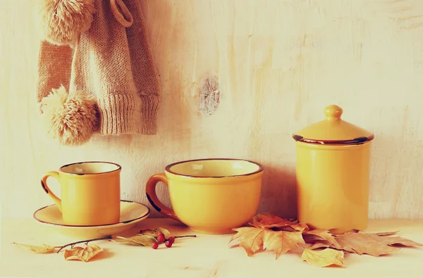 Set de tazas de café vintage y tarro sobre mesa de madera de textura rústica y hojas de otoño. imagen es retro filtrado — Foto de Stock
