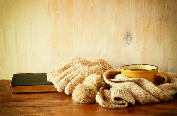 Taza de café negro con una bufanda caliente sobre fondo de madera. imagen filtrada — Foto de Stock