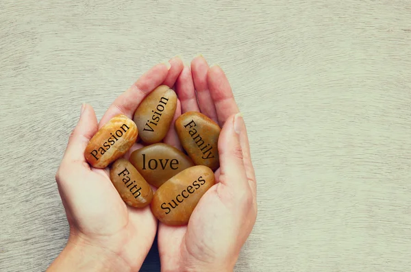 Woman holding river stones with words written on them. love, success and family concept — Stock Photo, Image