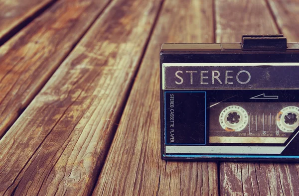 Old portable cassette player on a wooden background. image is instagram style filtered — Stock Photo, Image