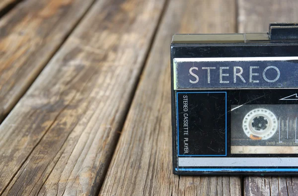 Old portable cassette player on a wooden background. image is instagram style filtered — Stock Photo, Image