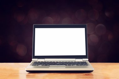 Laptop ile boş perde için alay yukarı ve bulanık bokeh arka plan hazır ahşap masa üzerinde