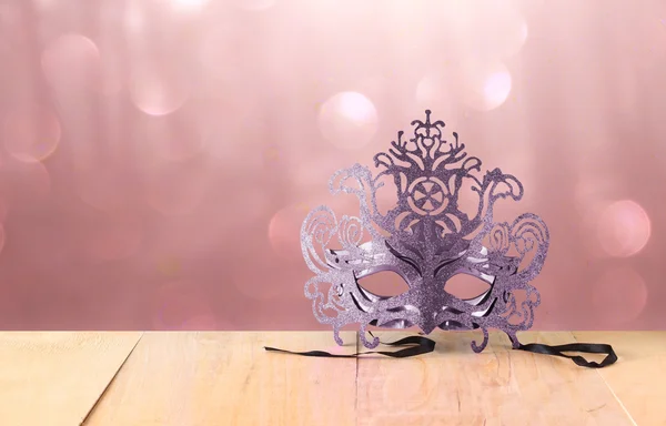 Titokzatos velencei maskara maszk fából készült asztal és csillogó háttér — Stock Fotó