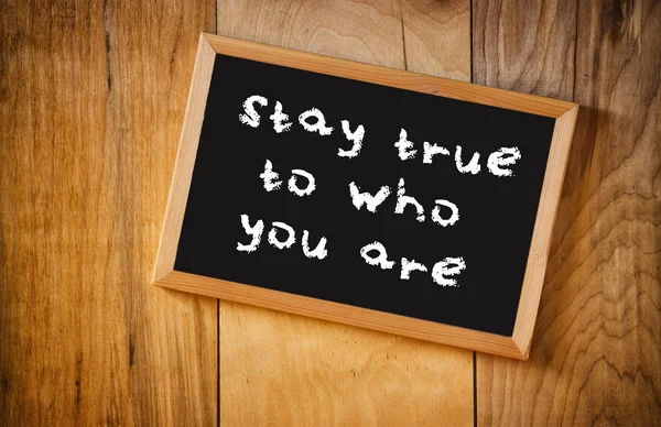 Top view of blackboard with the phrase stay true to who you are, over wooden background — Stock Photo, Image