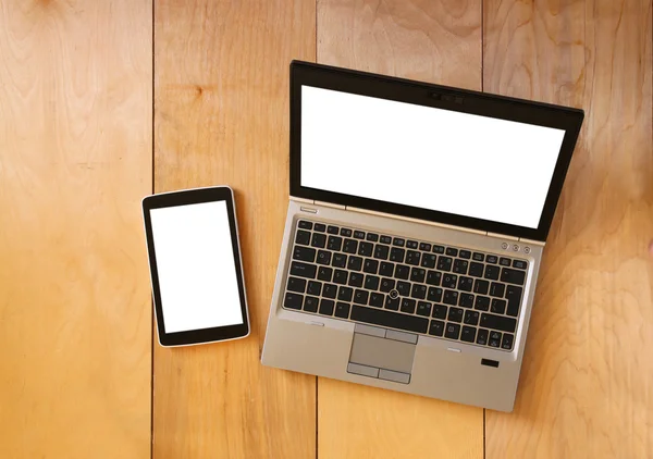 Top view of tablet device and laptop with blank screen ready for mock up