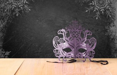 Ahşap masa ve kar tanesi kaplaması ile doku siyah arka plan üzerinde Telkari gizemli Venedik maskeli balo maskesi