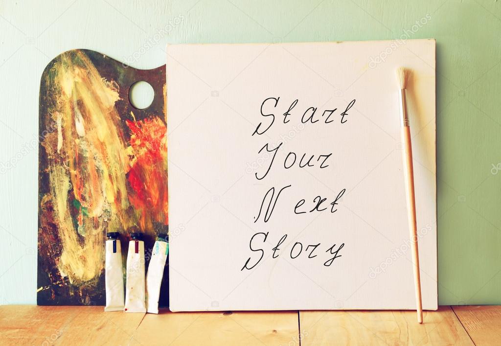 Canvas with the phrase start your next story next to oil paints and palette