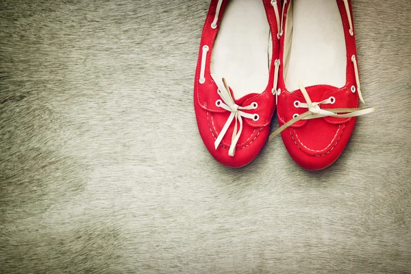 Vista superior de zapatos de mujer desgastados rojos sobre fondo texturizado de madera. filtro de estilo instagram —  Fotos de Stock